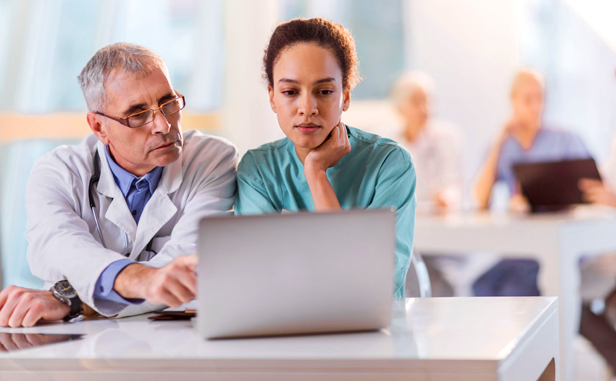 two doctors looking at a laptop