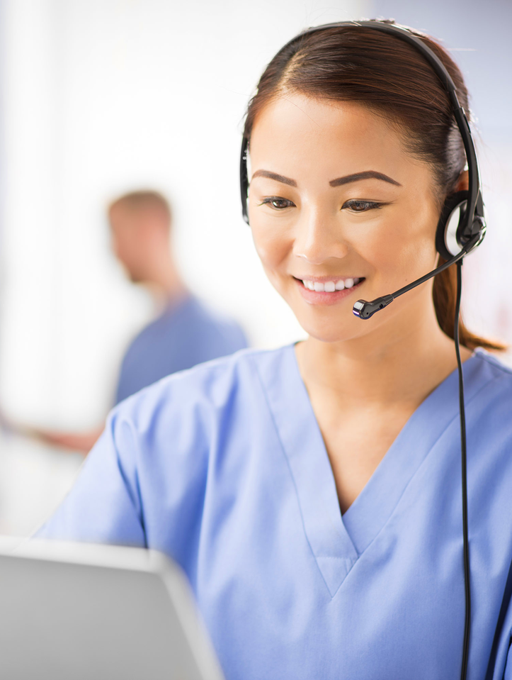 Nurse taking a call and looking at a laptop