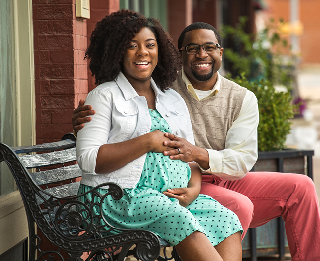 pregnant couple sitting on bench