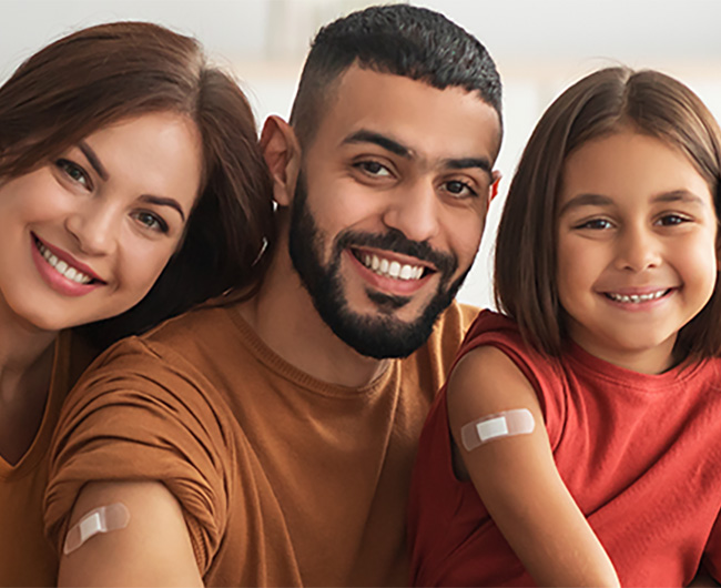 family with a bandaid on their arm from receiving a vaccine