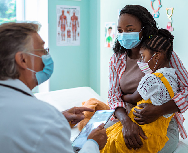 Doctor speaking to mother and daughter