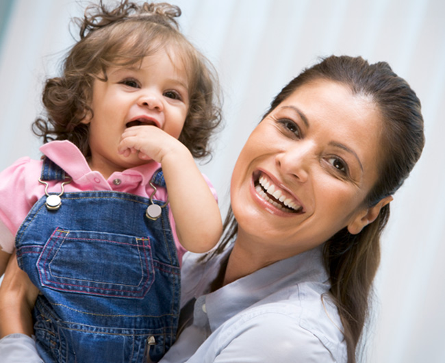 Smiling mother carrying daughter