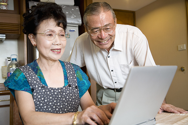 asian couple looking at computer