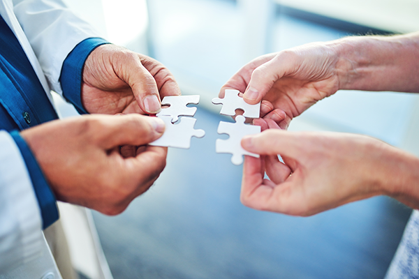 two hands holding puzzle pieces