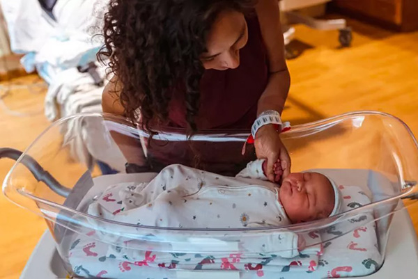 mom looking at newborn