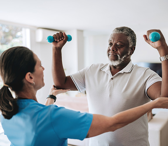 Trainer helping man lift weights